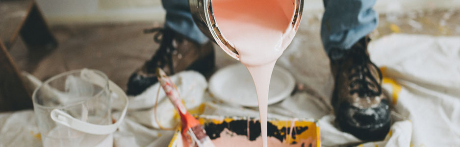 An example of a local painter and decorator pouring paint into a roller tray 